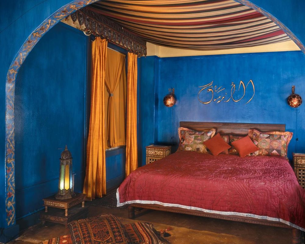 Синие стены спальни с дорогим текстилем