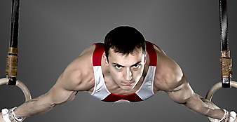 Мужчина гимнаст тренируется на кольцах. (Код изображения: 20025)